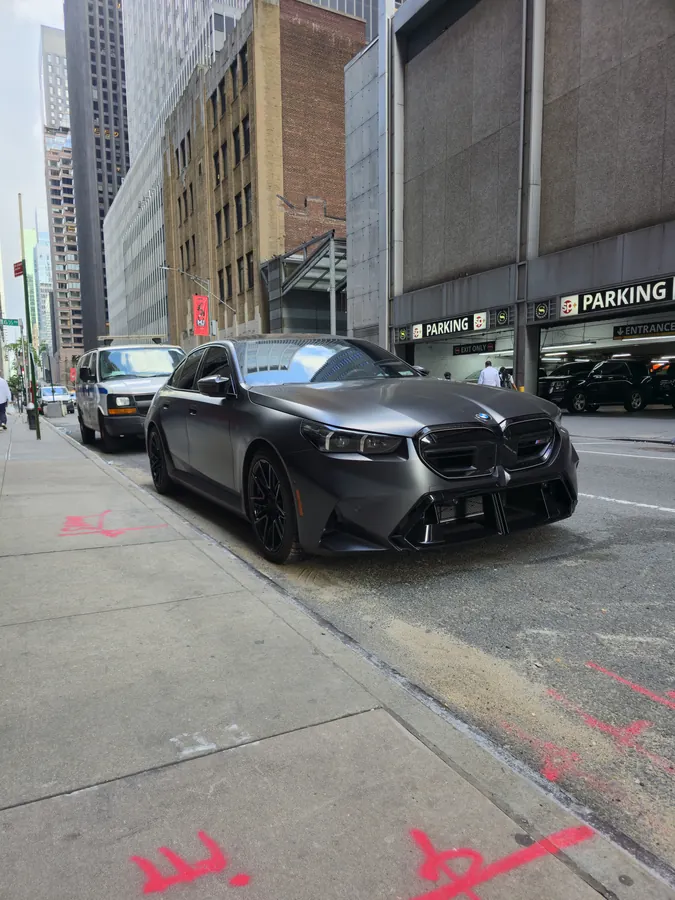A dark sports car parked on a New York street