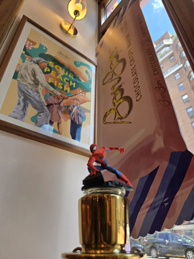 A small Spider-Man figure displayed beside colorful storefront artwork